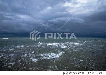 Dramatic seascape in dark colors. Dark sky with clouds over the stormy sea. 123406399