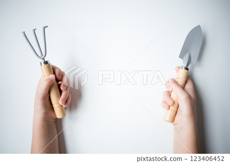 Childs hands holding gardening tools on white background Childs hands holding gardening tools on white background 123406452