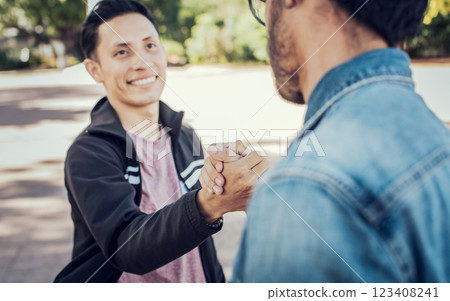 Two teenage friends shaking hands at each other outdoors. Two people shaking hands on the street. Concept of two friends greeting each other with handshake on the street 123408241