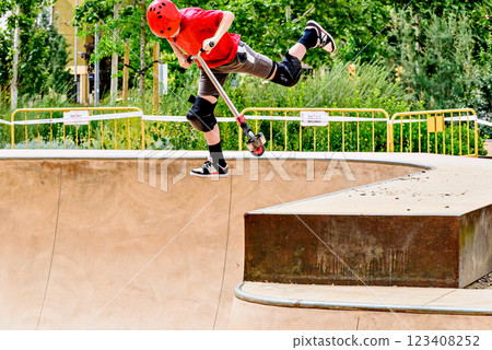 Young man practicing Scootering (Freestyle Scootering) in the new SkatePark in the central park of Igualada, Barcelona, Spain. 123408252