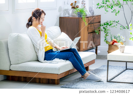Young woman using a computer in the living room Young woman using a computer in the living room 123408617