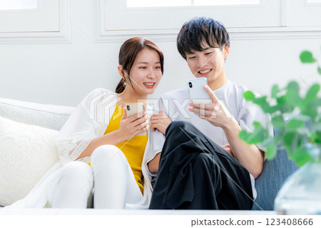 看一台智能手機的年輕夫婦在客廳 123408666