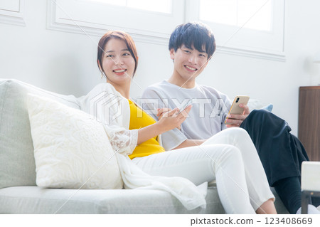 看一台智能手機的年輕夫婦在客廳 123408669