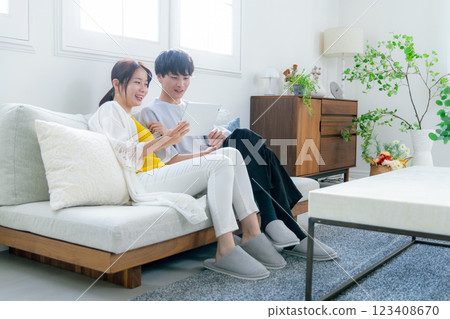 Tablet, young couple, living room Tablet, young couple, living room 123408670