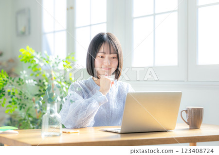 Young woman using a computer in the living room Young woman using a computer in the living room 123408724