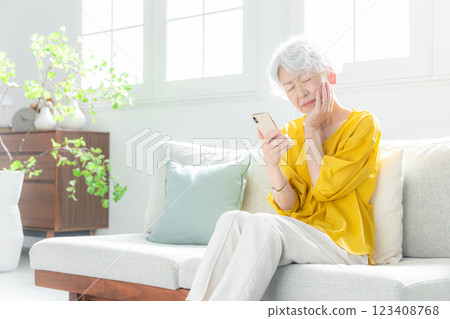 Senior woman looking anxiously at her smartphone 123408768