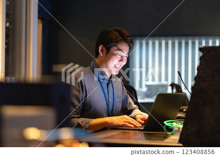 一名男子晚上在辦公室工作 123408856