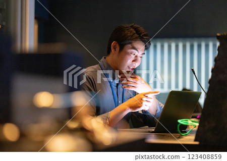 A man working at an office at night A man working at an office at night 123408859