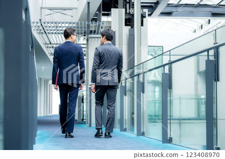 Businessman walking in the office corridor Businessman walking in the office corridor 123408970