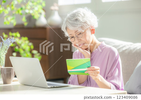 Worried senior woman, bankbook balance 123409086