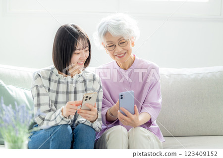 操作智慧型手機的高階女性和年輕女性 123409152