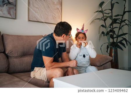 Caucasian male and hispanic child sharing a moment on couch 123409462
