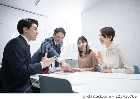 Businessman having a meeting in a conference room, pointing at a document 123410769