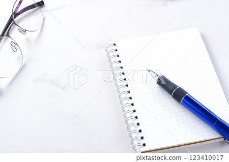 An image of doing desk work with a ring-type notepad and pen 123410917