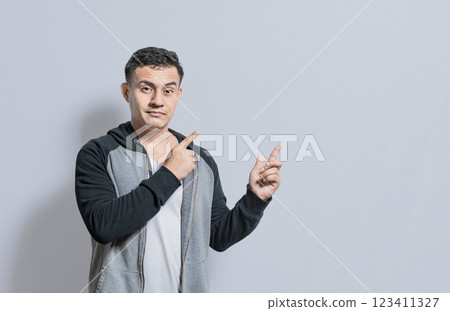 Smiling handsome man recommending something with fingers isolated, isolated people pointing fingers at something, Smiling person pointing fingers to the side 123411327