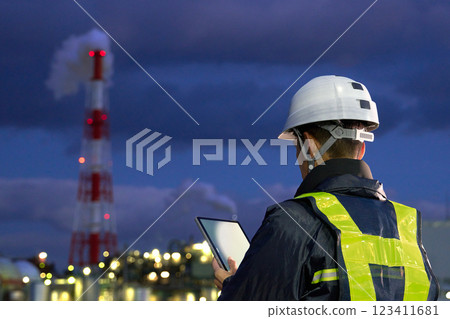 Back view of a worker working at a site at night 123411681