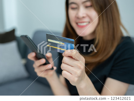 Asian woman while using credit card for shopping online on mobile phone applications. Asian woman while using credit card for shopping online on mobile phone applications. 123412021