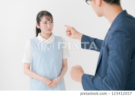A woman in an apron responding to a customer A woman in an apron responding to a customer 123412057