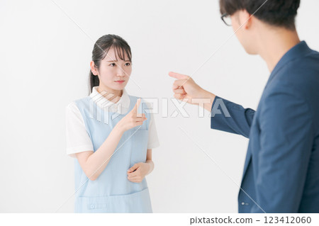 A woman in an apron responding to a customer 123412060