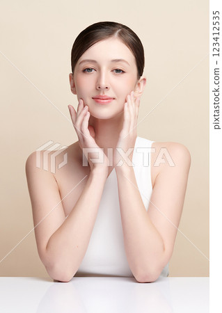Beautiful young woman with clean fresh skin on beige background, Face care, Facial treatment, Cosmetology, beauty and spa, women portrait. 123412535