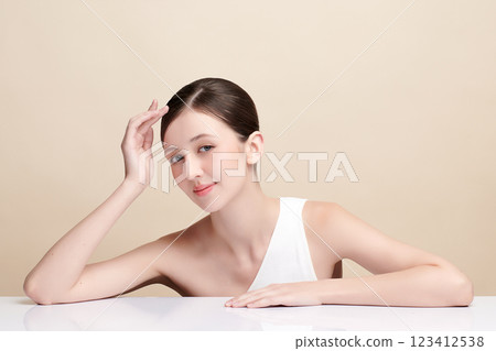 Beautiful young woman with clean fresh skin on beige background, Face care, Facial treatment, Cosmetology, beauty and spa, women portrait. Beautiful young woman with clean fresh skin on beige background, Face care, Facial treatment, Cosmetology, beauty and spa, women portrait. 123412538