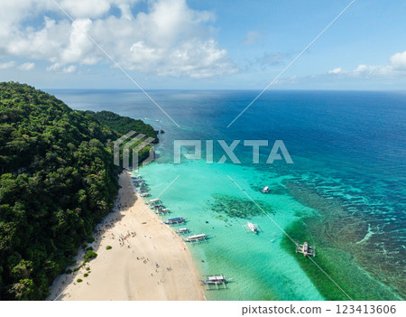 Ocean waves on white sand, boats floating over clear turquoise water. Puka Shell Beach. Boracay, Philippines. 123413606