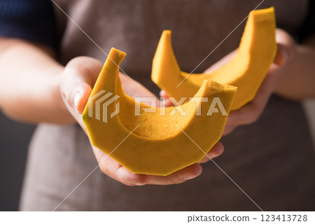 Section and peeled pumpkin holding by hand, Homemade cooking Section and peeled pumpkin holding by hand, Homemade cooking 123413728