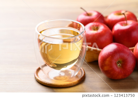 Glass of apple cider and red apple fruit on wooden background 123413750