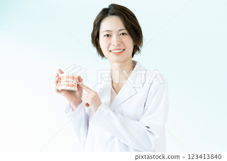 Dentist woman holding a tooth model Dentist woman holding a tooth model 123413840