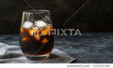 Freshly brewed cold coffee with ice in clear glass on dark background 123415385