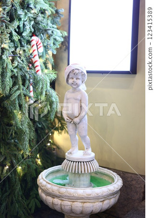 An Elegant Garden Fountain Featuring a Beautiful Cherub Statue Set in a Festive Atmosphere An Elegant Garden Fountain Featuring a Beautiful Cherub Statue Set in a Festive Atmosphere 123415389