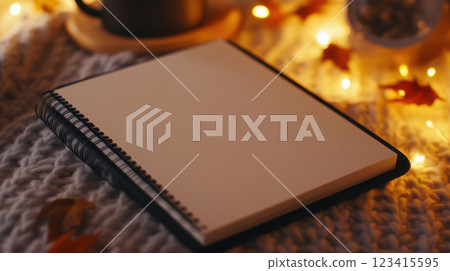cozy flat lay of clean notebook page surrounded by warm lights cozy flat lay of clean notebook page surrounded by warm lights 123415595