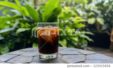 refreshing iced coffee with hint of vanilla syrup, surrounded by lush greenery 123415858
