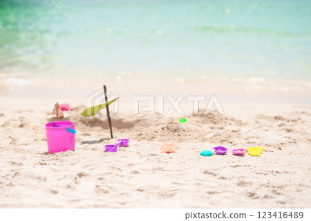 colourful beach toys on tropical beach, Children bucket, spade and other toys on beach against beautiful sea. Summertime and vacation Concept colourful beach toys on tropical beach, Children bucket, spade and other toys on beach against beautiful sea. Summertime and vacation Concept 123416489