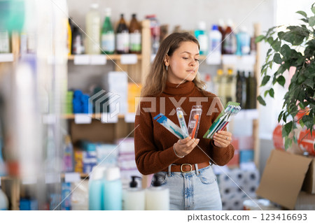 Young woman choosing toothbrush in store 123416693