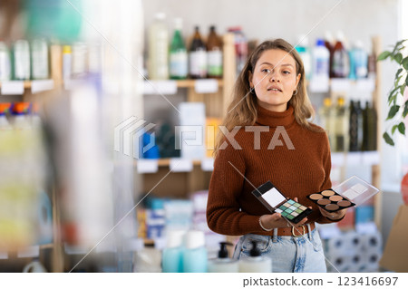 Young woman choosing eyeshadow and sculptor in store 123416697
