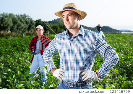 Portrait of satisfied farmer in front of his farm on sunny summer day 123416799