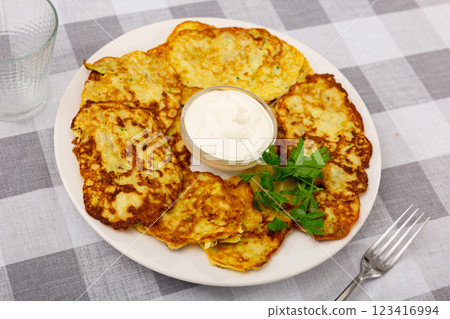 On plate are vegetable pancakes made from grated zucchini On plate are vegetable pancakes made from grated zucchini 123416994