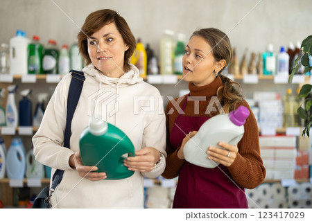 Female saleswoman offers woman buy detegrent in supermarket Female saleswoman offers woman buy detegrent in supermarket 123417029