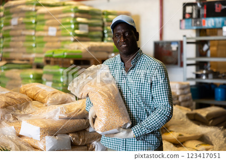 African american worker stacks bags of products in large warehouse African american worker stacks bags of products in large warehouse 123417051