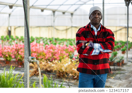 Portrait of male hired worker in greenhouse where flowers are grown 123417157
