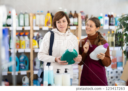 Female saleswoman offers woman buy detegrent in supermarket 123417263
