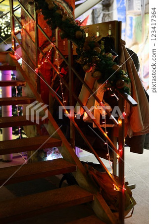 A festive staircase adorned with bright lights and garland, creating a joyful holiday feel A festive staircase adorned with bright lights and garland, creating a joyful holiday feel 123417364