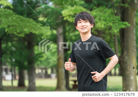 Young man walking/jogging/running/exercising/aerobic exercise/training in the park 123417679