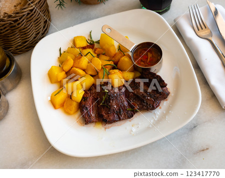 Entranya skirt steak, grilled beef with potatoes and sause closeup Entranya skirt steak, grilled beef with potatoes and sause closeup 123417770