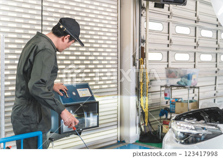 Male staff of car mechanics and inspectors working at a repair shop Male staff of car mechanics and inspectors working at a repair shop 123417998