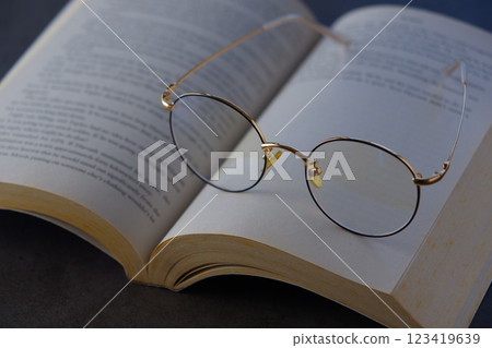 一張圖片：某人在打開英文平裝書時放鬆並享受閱讀的樂趣。 123419639