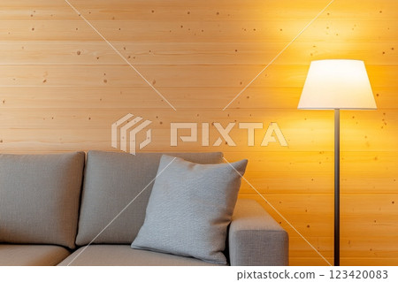 A cozy living room featuring warm pine wood walls and a modern sofa 123420083