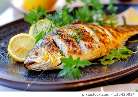A beautifully grilled Tai sea bream garnished with lemon slices and fresh herbs A beautifully grilled Tai sea bream garnished with lemon slices and fresh herbs 123420084