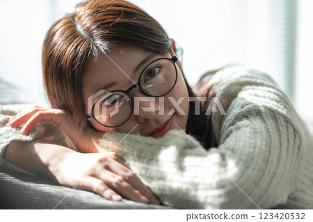 Woman with glasses smiling on sofa 123420532